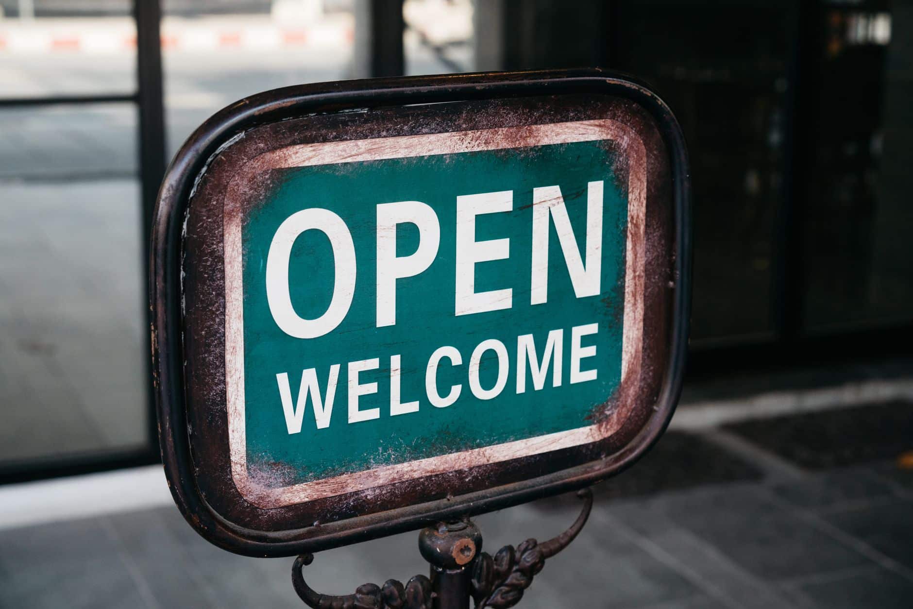 close up of a rusty sign saying open welcome