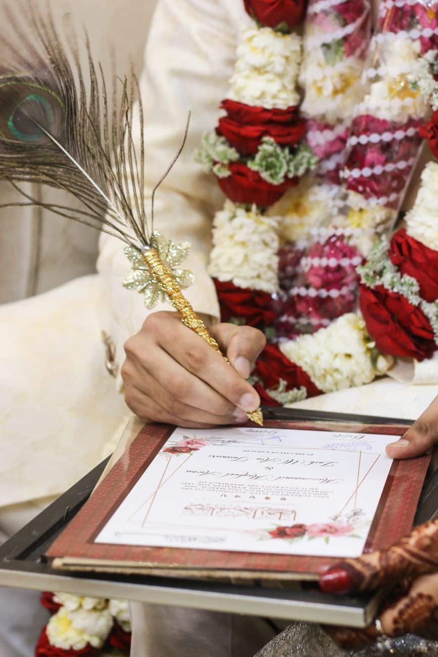 a man holding a pen and writing on a piece of paper